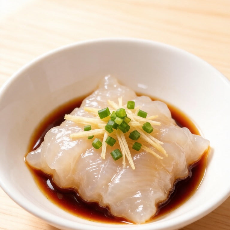 Rehydrated fish maw in a white bowl with a glossy braising sauce and scallion